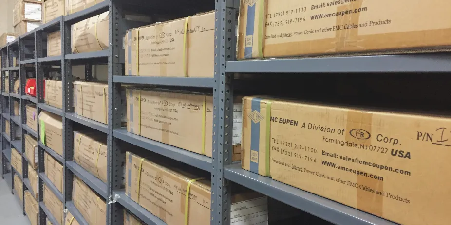Shelves filled with organized archive boxes in a storage room.