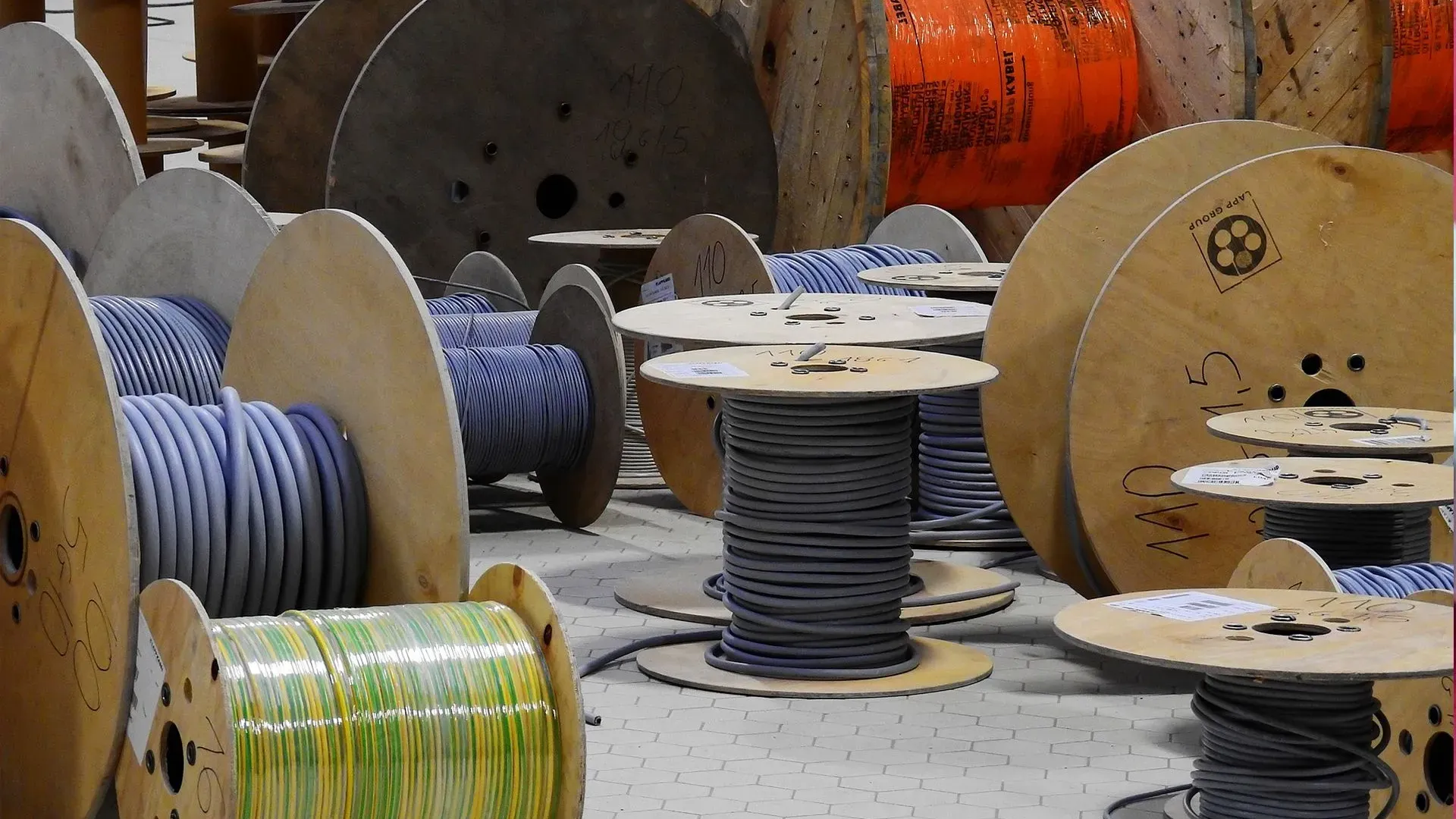 Large spools of industrial cables in a warehouse setting.